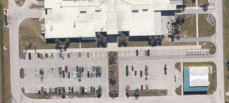 Aerial view of a commercial site with parking lot, drive lanes, and sidewalks
